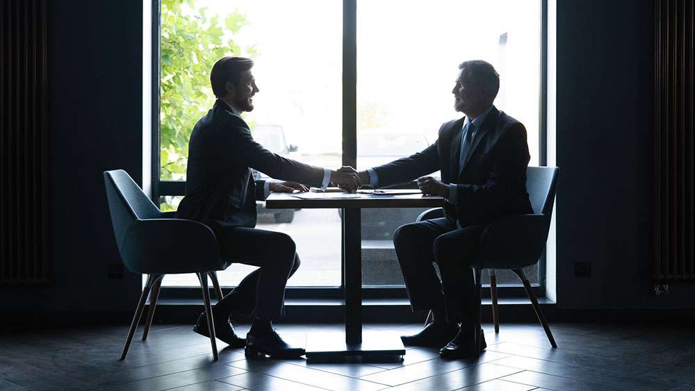 Agent and client shake hands after successfully negotiating a real estate deal