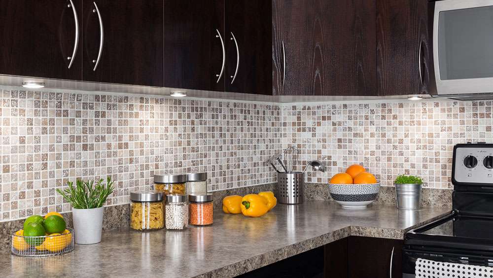 Kitchen remodel with new countertop, backsplash, under-cabinet lighting, and new cabinet doors and hardware.