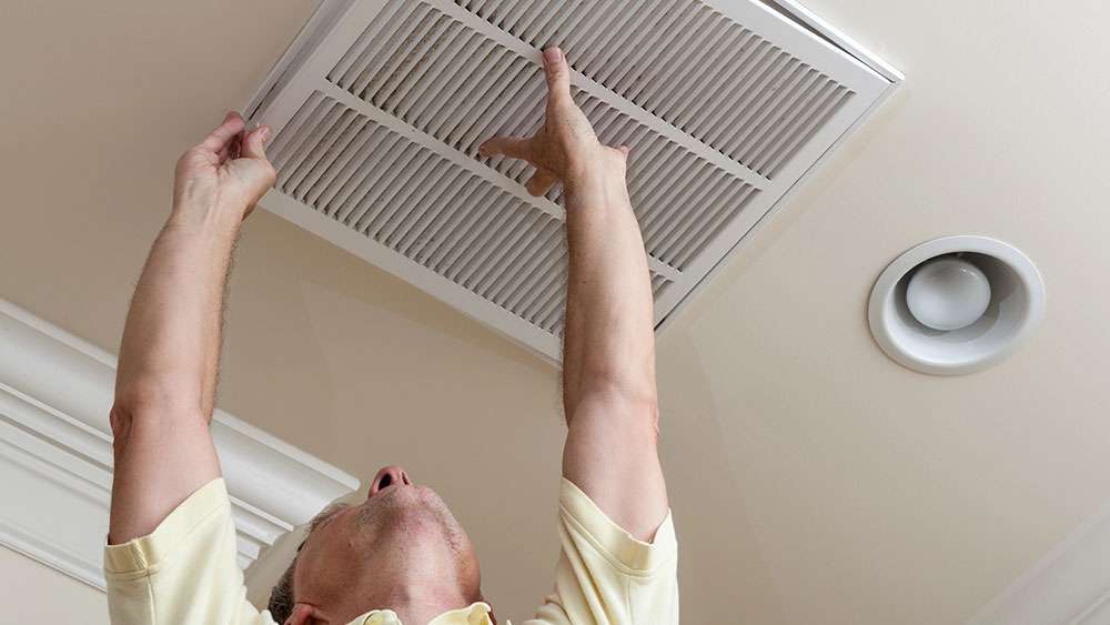 Man changing a ceiling air filter