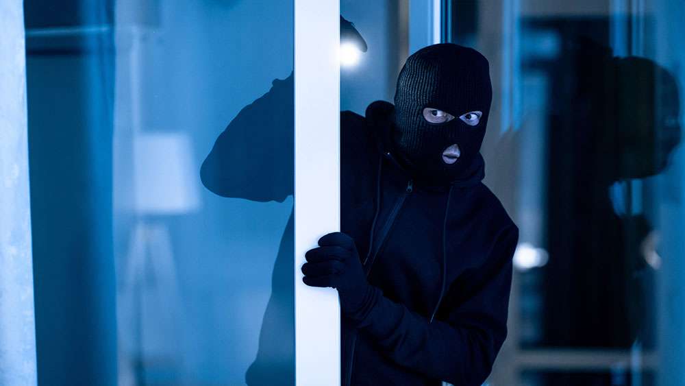 Masked robber breaks into a home at night