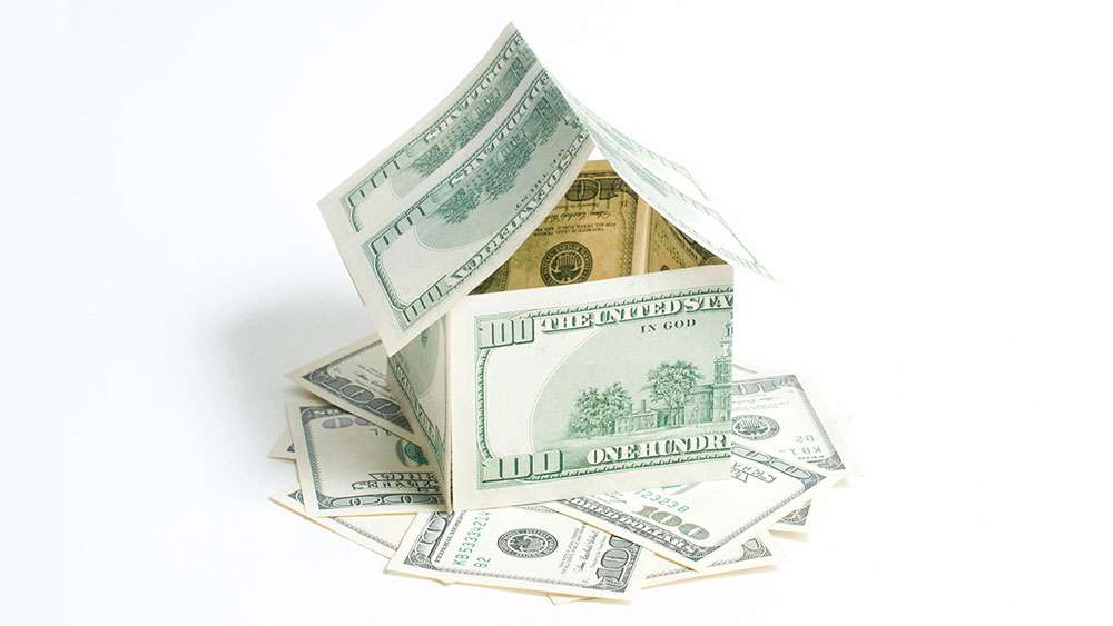 House made of one hundred dollar bills and sitting on a pile of one hundred dollar bills.