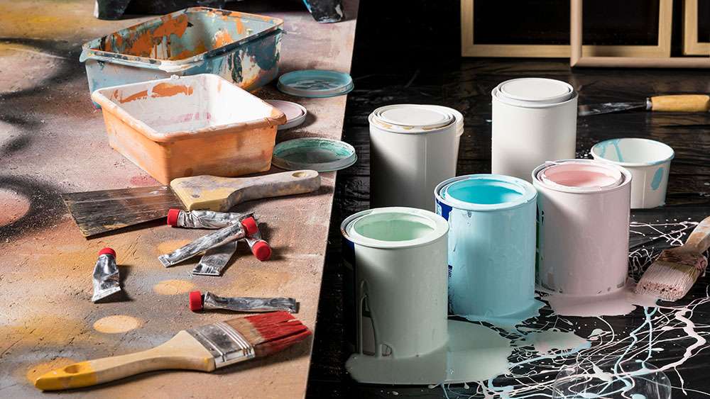 Paint supplies and paint cans sitting in spilled paint