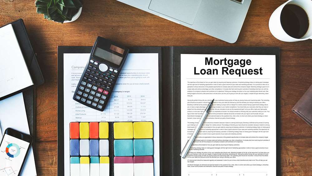 Mortgage Loan Request paperwork on desk with calculator and other documents